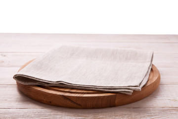 Napkin and board for pizza on wooden desk. Canvas, dish towels on white wooden table background top view mock up. Selective focus.