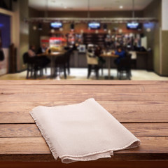 Wood table with napkin blured background cafe , for your photo montage or product display. Space for placing items on the table.