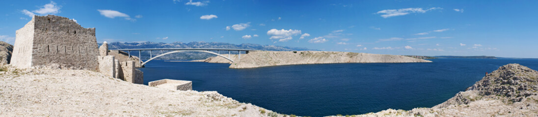 Croazia: vista panoramica delle rovine di una torre di guardia e del Paški Most, il ponte del 1968...