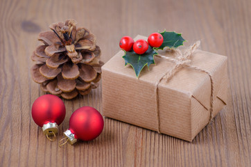 vintage christmas card with a gift box and holly berries on wooden background