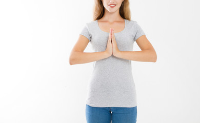 Close-up of hands of pretty woman, girl in t-shirt , meditating indoors, focus on arms in Namaste...