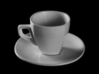 White coffee cup and saucer isolated on black background