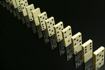 Domino knuckles lined up one by one on a black glass table
