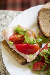 Wholegrain bread sandwich with ham, tomato and basil 