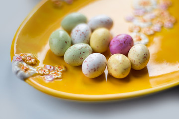 Colorful chocolate Eater eggs on a yellow plate