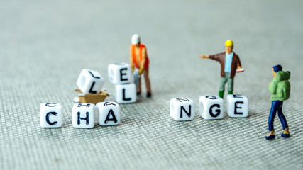 Removing white cubes with letters l and e of the word challenge creating new word change on grey background with miniature figurines - obrazy, fototapety, plakaty