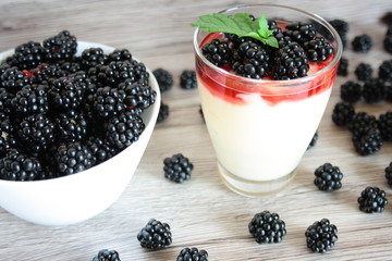 Dessert with blackberries, vanilla cream and a mint leaf
