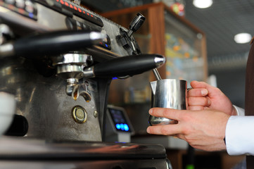 Barista making coffee. Prepairing milk for cappuccino