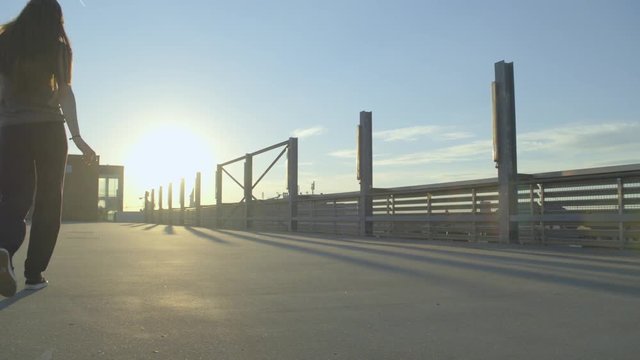 female Dancer walks into the frame, dancing hip hop on a concrete envoirenment 