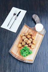 Breaded deep fried mushrooms with mayonnaise dip. Fried fried mushrooms champignons and sauce on a wooden board