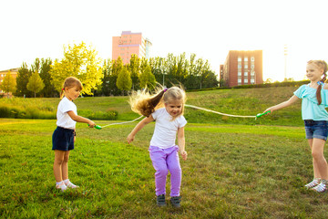 Obraz premium three cheerful girls are played with a rope