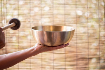 Girl holding a Tibetan bowl & striker 