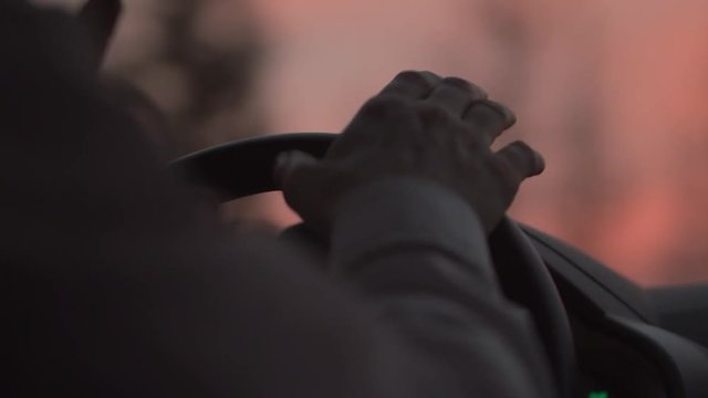 A Man's Hand Drummed On The Steering Wheel Of The Car.