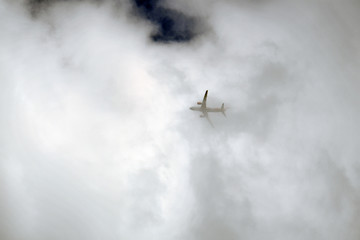 Fototapeta na wymiar A airplane flies through a wall of clouds.