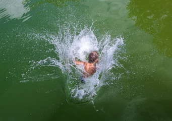 Junge springt in See, Wasser spritzt