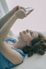 Naklejka premium young redhead beauty smiling with smartphone 