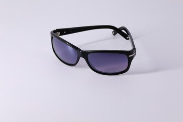 Sunglasses made of dark material and dark glasses, subject shooting on a light background.