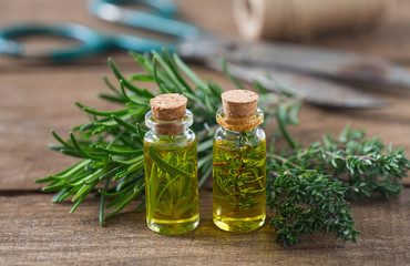 olive oil with herbs on wooden surface