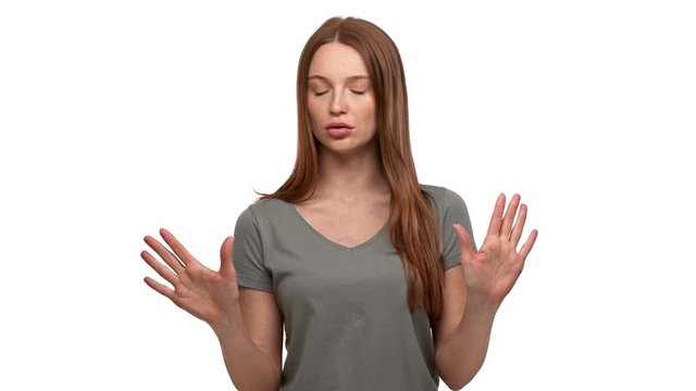Portrait of disappointed ginger woman 20s expressing perplexity and confusion with showing stop gestures and saying no, isolated over white background. Concept of emotions