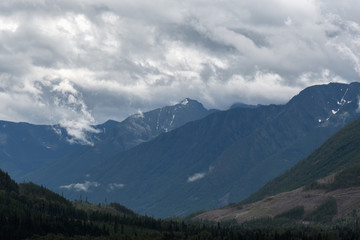 Naklejka na ściany i meble Heavy rain moves across a dramatic valley in the Canadian wilderness