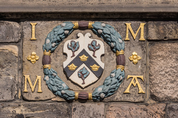 Obraz na płótnie Canvas Edinburgh, Scotland, UK - June 13, 2012; Closeup of plate set on Metcat Cross near St. Giles Cathedral, featuring emblem with Scottish flag and castle symbol.