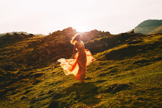 Beautiful woman run in fashion dress on nature