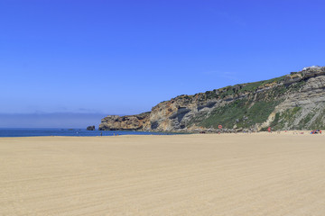 The beach of Nazare, Portugal. A small Portuguese town on the Atlantic coast. Rocks and sea.