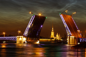 Naklejka na ściany i meble Defocused city landscape of raised Palace bridge above river Neva. White night in Saint-Petersburg, Russia.