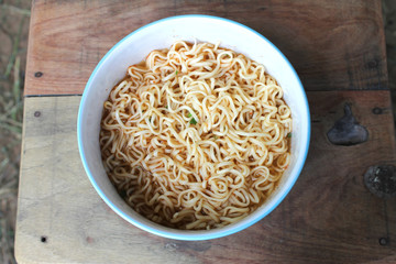 instant noodles  in blue bowl on the wooden background.