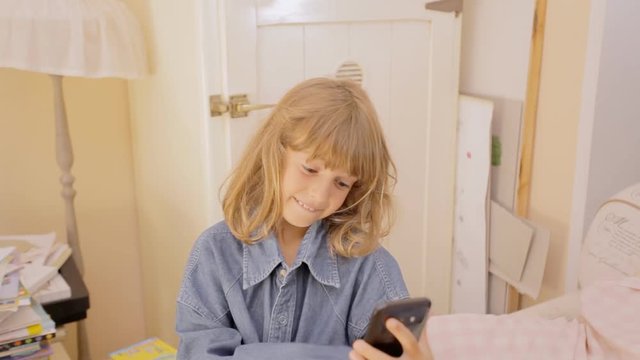 A cute little girl wearing an oversize shirt, shooting selfies and having fun.
