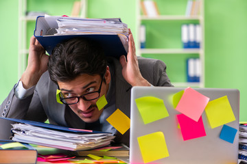 Businessman unhappy with many conflicting priorities sitting in 