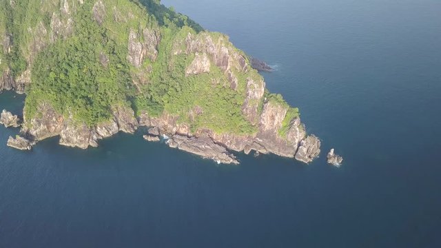 Aerial drone view of a large, uninhabited limestone island jutting up out of a tropical ocean (Mergui Archipelago, Myanmar)