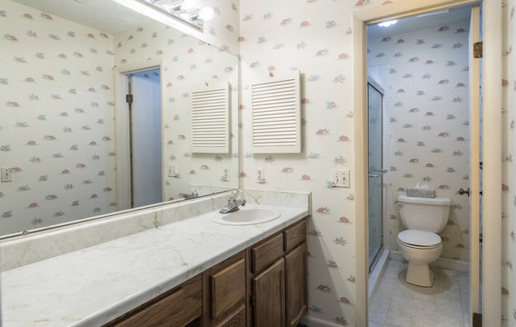 Interior Of Dated 1980s Home Bathroom With Single Sink And Toilet.