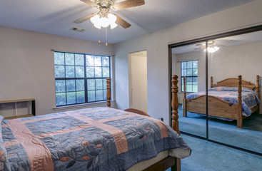 Simple vintage 1980s bedroom with blue carpet.