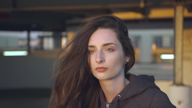 Young Girl appears into the frame, putting her hoody on and walks away.