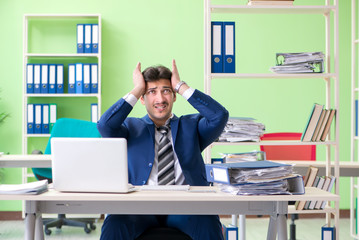 Businessman unhappy with excessive work sitting in the office 