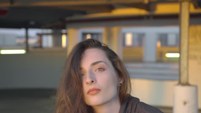 Young hip hop dancer dancer gets up with a very cool attitude and puts on her hood, looks into the camera and walks away