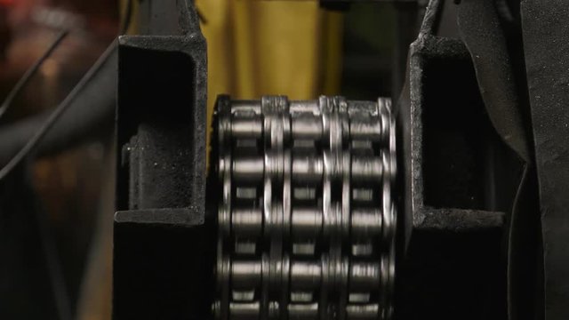Production of steel screws in the factory ferrous metals. Hot red and orange nuts fall from the top to the container. Closeup