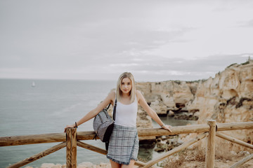 Fototapeta na wymiar Young woman with backpack Traveler on background beach seascape horizon. Tourist look on blue sun ocean, summer lifestyle