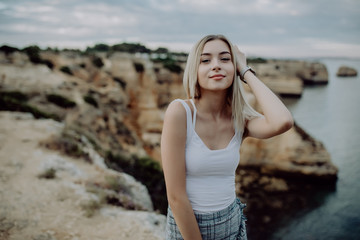 Portrait of attractive woman posing on rocky beach with beauty landscape.