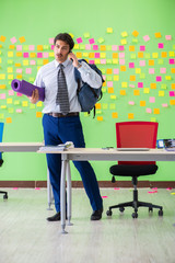 Man in the office with many conflicting priorities preparing go 