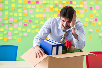 Man collecting his stuff after redundancy in the office with man