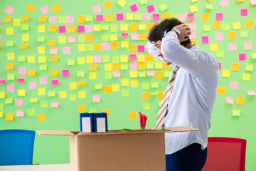 Man collecting his stuff after redundancy in the office with man
