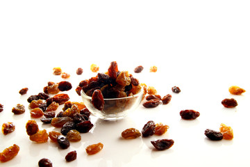 Obraz premium Raisins on white background / A raisin is a dried grape. Raisins are produced in many regions of the world and may be eaten raw or used in cooking, baking, and brewing