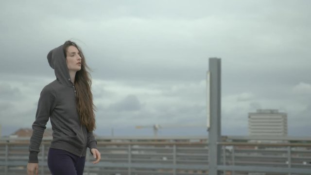 young female Urban dancer opens her hoody and throw it behind her