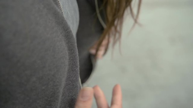 Urban dancer opens her hoody and throw it behind her, close up