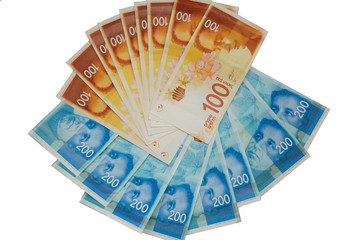 New israeli sheqalim in stack with a paper clip on white background.