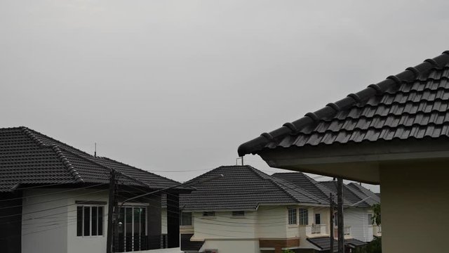 slow motion rainy day scene, house with water pouring rain on moody sky