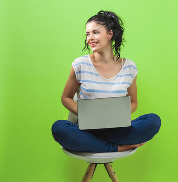 Young Woman Using Her Laptop On A Green Background