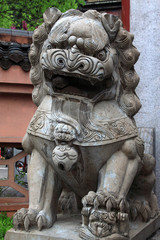Fototapeta na wymiar gray lion stone carving at the entrance of a temple